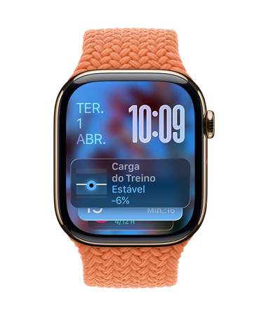 Apple Watch com caixa dourada de titânio e pulseira trançada tangerina, o mostrador exibe a data no canto superior esquerdo, a hora com os números organizados no canto superior direito, o widget Carga de Exercício na parte inferior, tudo em Liquid Glass translúcido