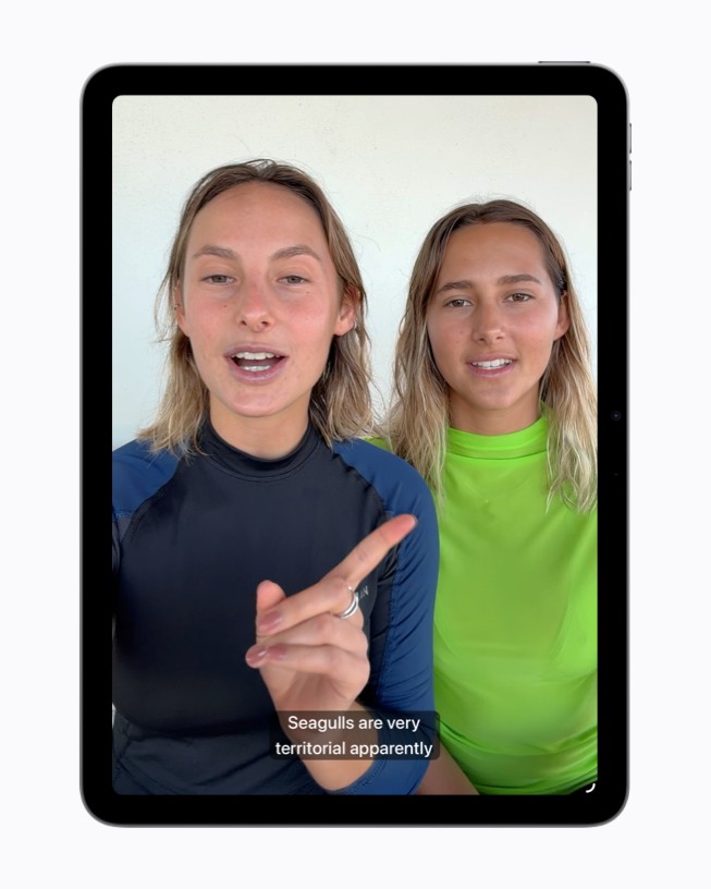 إطار من فيديو على iPad يعرض شخصين يتحدثان، مع ظهور الترجمة المصاحبة المُنشأة في أسفل الشاشة.