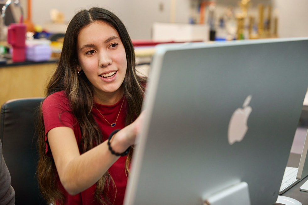 Imagen de Melissa Fourkiller sentada frente a una iMac en un aula.