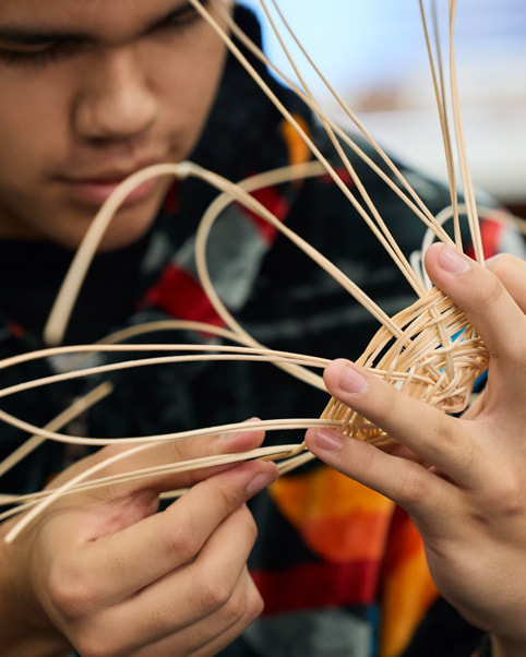 Imagen de un estudiante practicando el tejido de cestas.