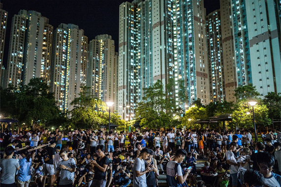 A mass of people playing Pokémon Go in a park at night in Hong Kong.