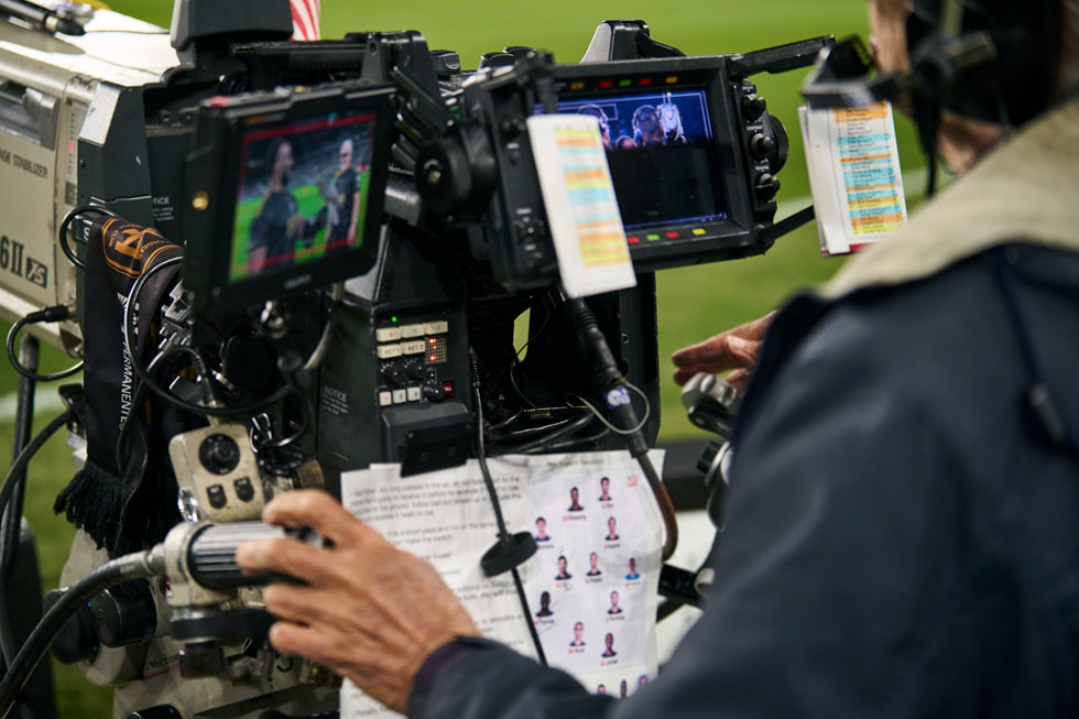 
A camera operator stands on the field at BMO Stadium during an LAFC game.

